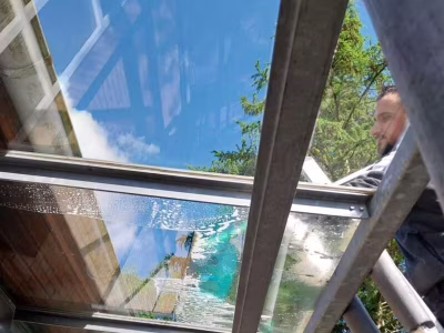 Fensterputzer-reinigt Ueberdachung ueber der Eingangstuer in Hamburg